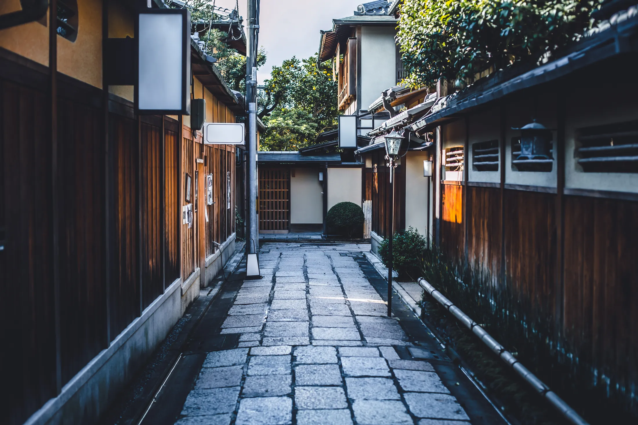 夕暮れの路地に並ぶ提灯の灯り